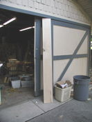 The maple board leans against the garage