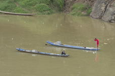 red-clad fisherman on narrow boat