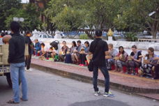 many tourists waiting to give alms