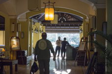 Mark, in shadow, walks toward the hotel front door