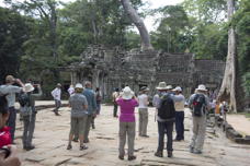 people standing around in front of the ruins